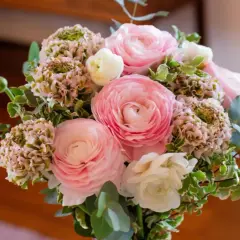 Un bouquet de fleurs roses et blanches, composé de renoncules et d'hortensias, prêt à être ajouté à la liste de souhaits du fleuriste.