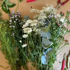 Un assortiment de feuillage pour bouquet, prêt à être assemblé. Des fleurs blanches, roses et violettes se mêlent à des feuilles d'eucalyptus.