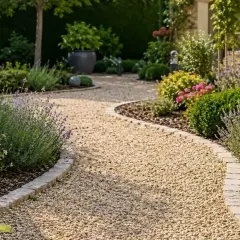 Une allée de jardin facile à faire serpente à travers des parterres de lavande, d'hortensias et de buis. Des bornes lumineuses éclairent le chemin.