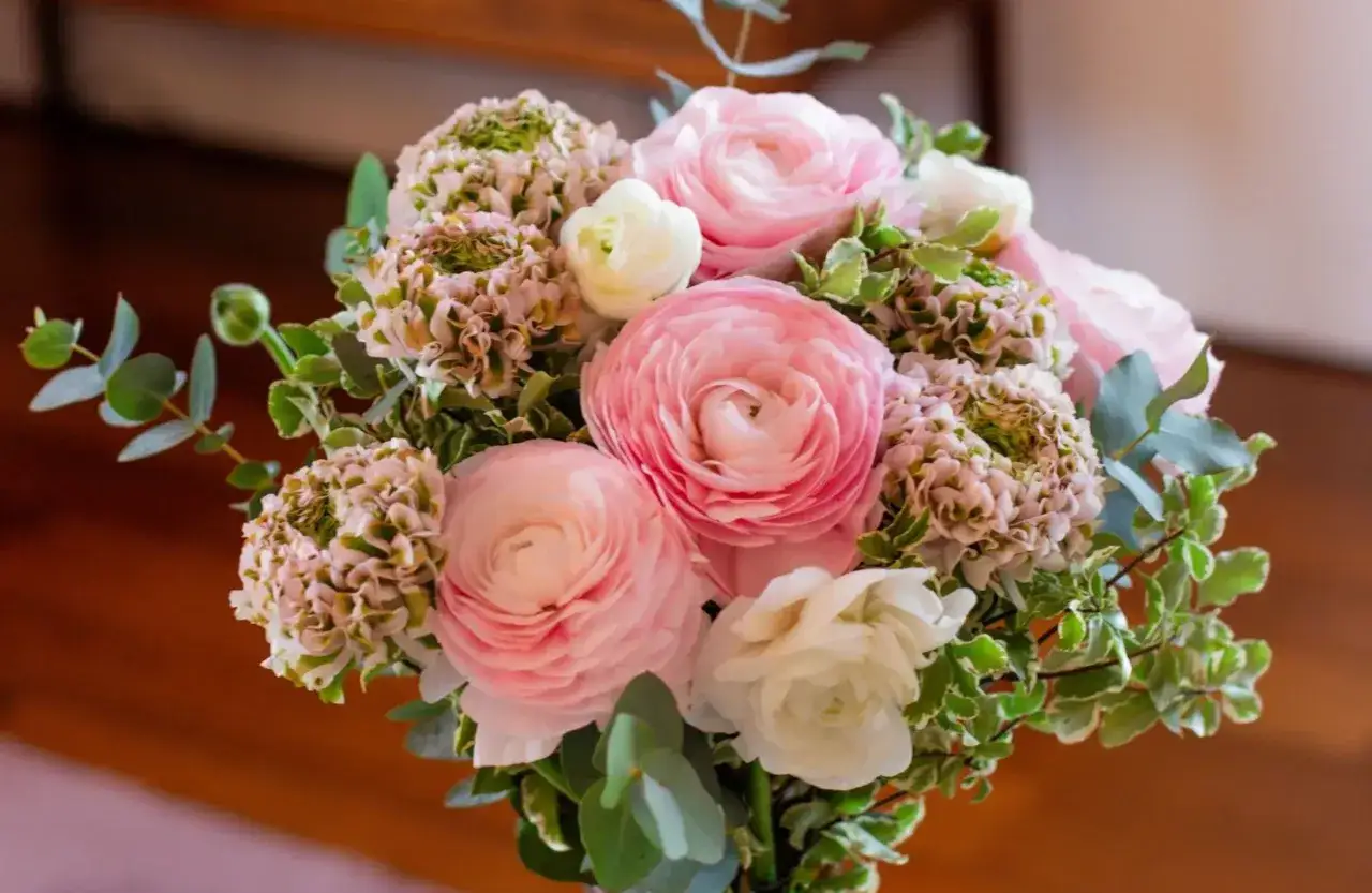 Un bouquet de fleurs roses et blanches, avec des touches de verdure, pr&ecirc;t &agrave; &ecirc;tre ajout&eacute; &agrave; la liste de souhaits du fleuriste.