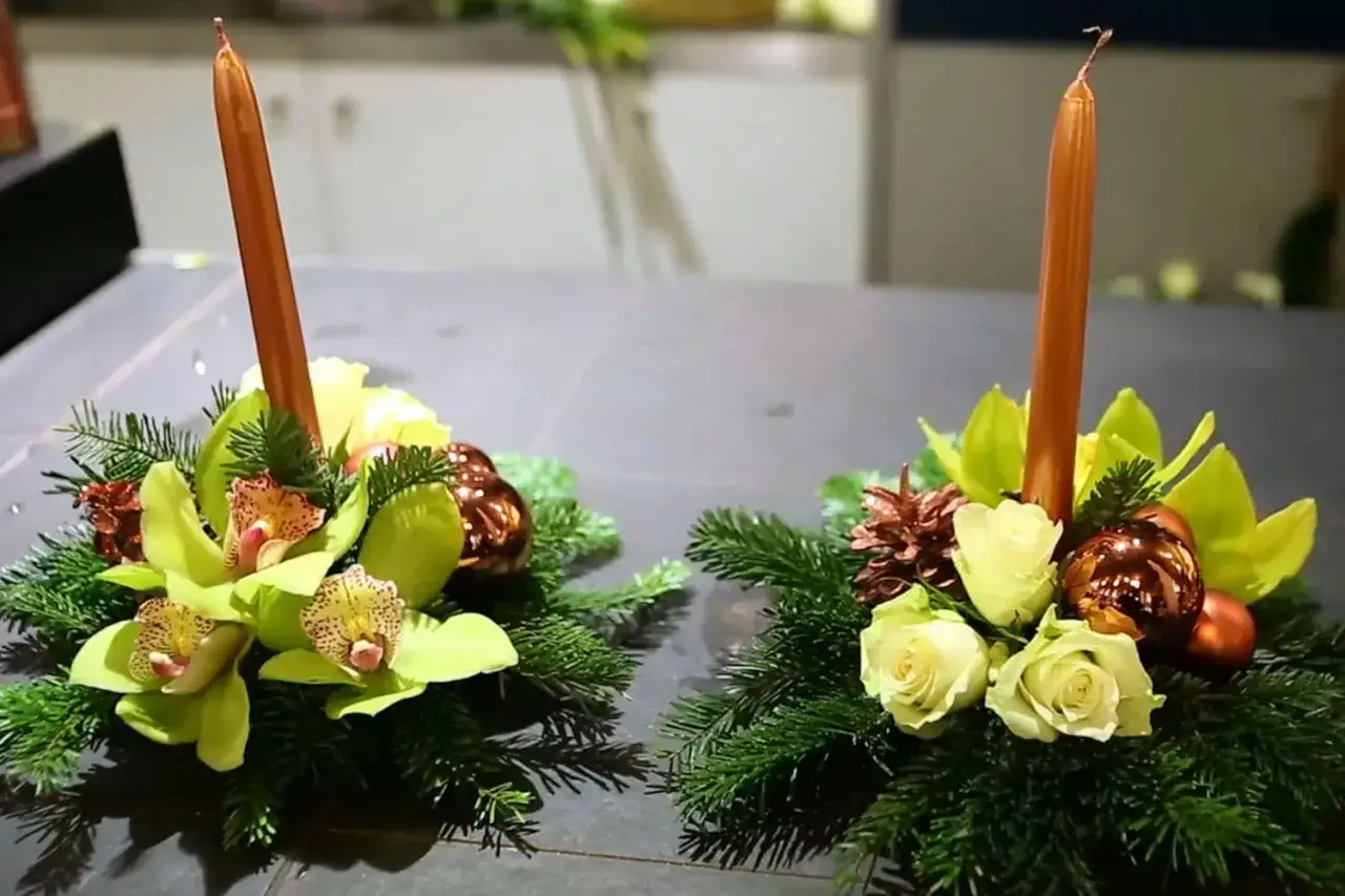 Deux centres de table festifs avec bougies, orchid&eacute;es, roses, boules de No&euml;l et branches de sapin. Un bouquet de No&euml;l &agrave; faire soi-m&ecirc;me pour une ambiance chaleureuse.
