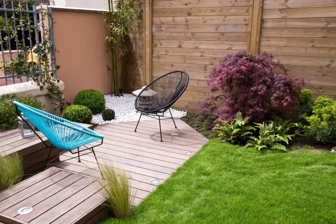 Am&eacute;nagement d'un petit jardin de 10m2 avec terrasse en bois, mobilier color&eacute;, bambous et &eacute;rable japonais. Un espace cosy et moderne.