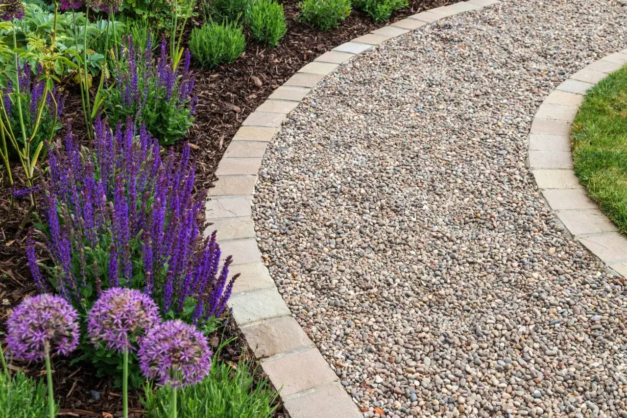 Une all&eacute;e de jardin facile &agrave; faire, bord&eacute;e de gravier et de fleurs violettes &eacute;clatantes. Un chemin invitant pour se promener.