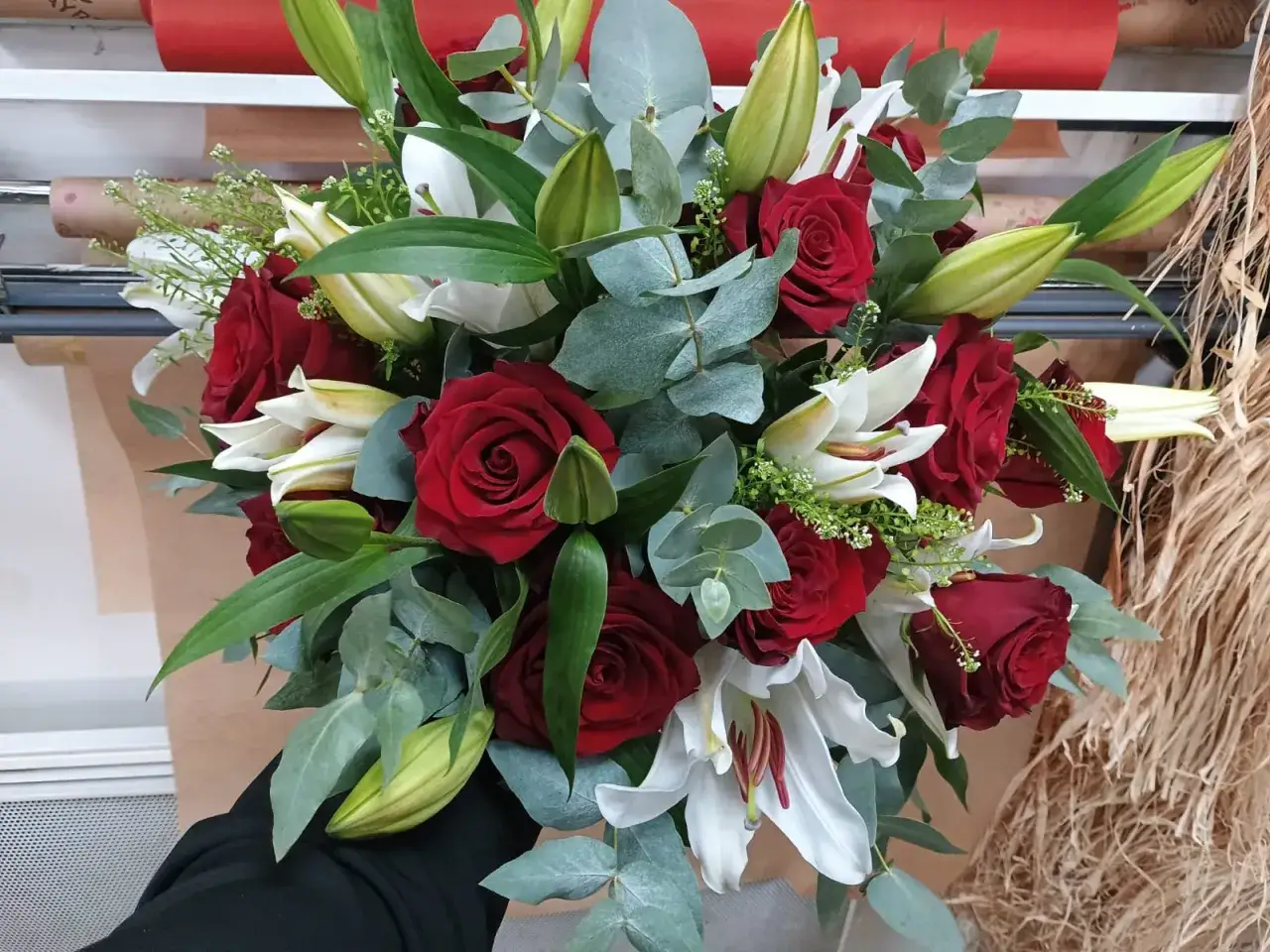 Un bouquet de roses rouges et de lys blancs, symbolisant la passion et la pureté. Le lys rouge signification est souvent associée à l'amour ardent.
