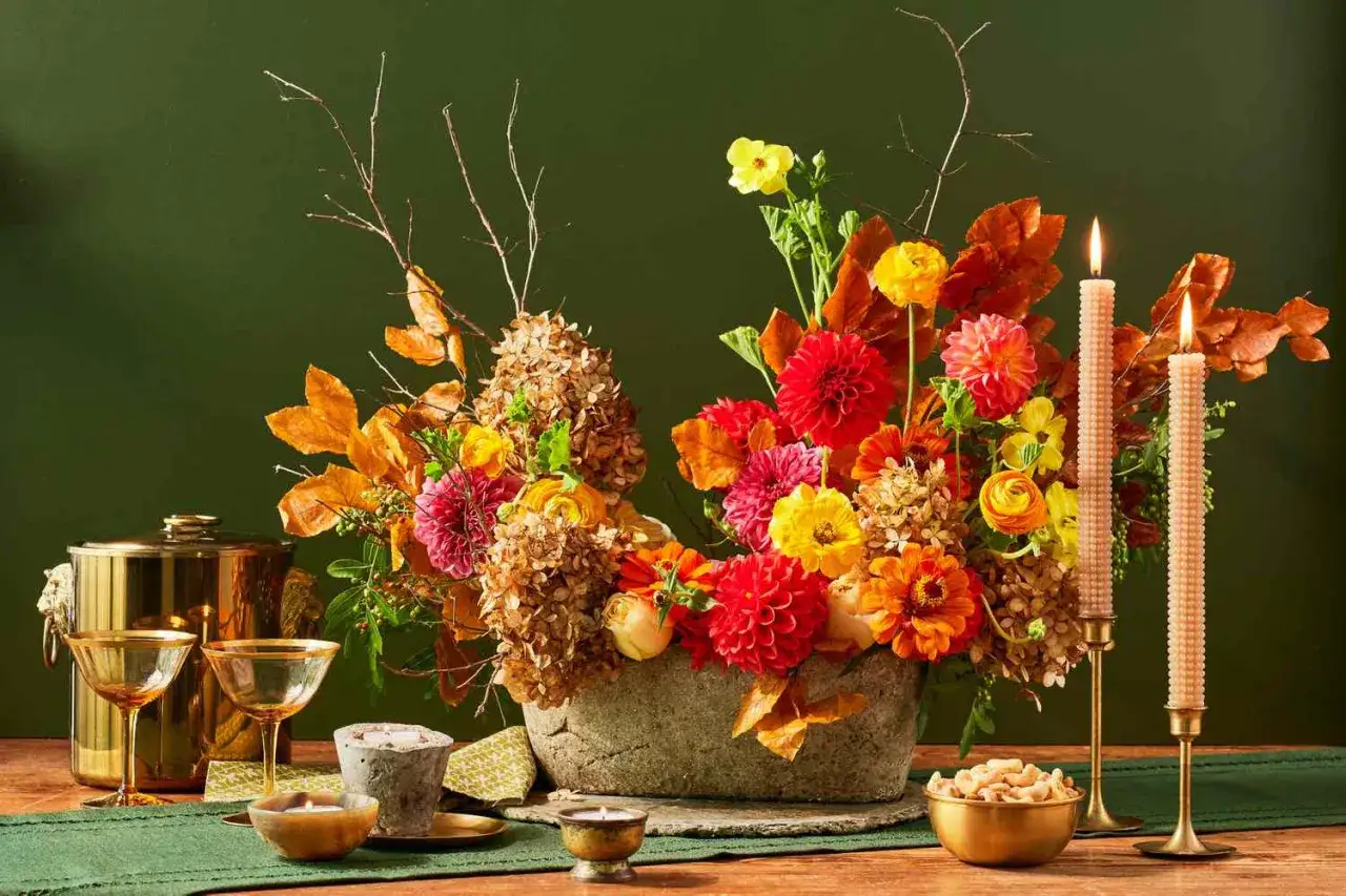 Un bouquet d'automne aux couleurs vives, avec des dahlias rouges et jaunes, des feuilles d'automne et du feuillage pour bouquet.